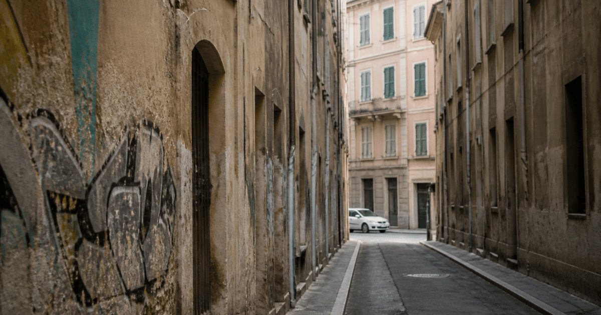 Rue etroite de Frejus avec immeubles degrades et graffitis visibles