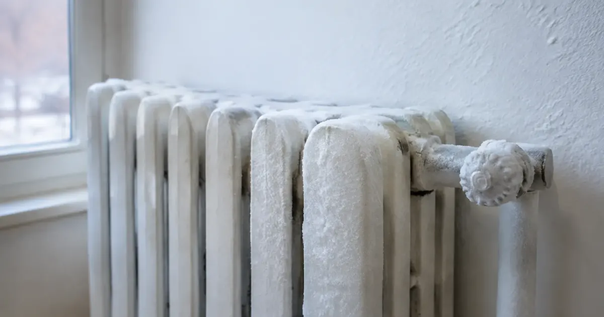 Main appuyee radiateur froid givrant mur blanc