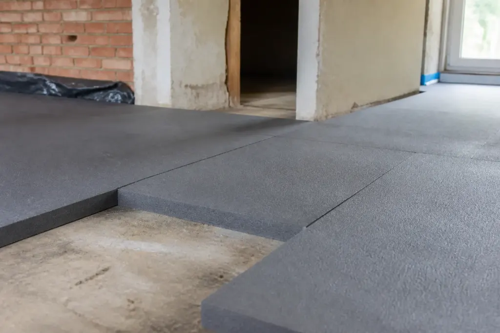 Plaques isolantes grises posees sur un sol en chantier