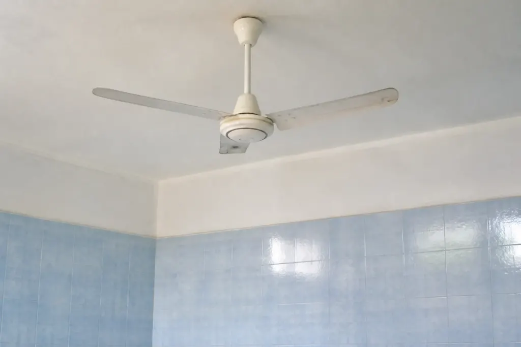 Ventilateur blanc fixe au plafond, carrelage bleu clair